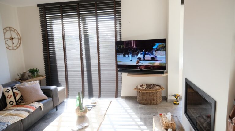 Woonkamer met tv op draaibare beugel en SONOS home cinema in een privéwoning te Voorde