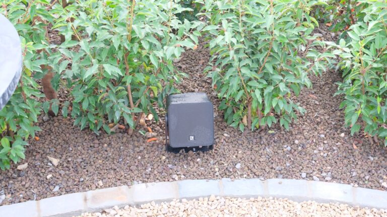 AUDAC VIRO5-luidspreker tussen de beplanting in de tuin te Voorde