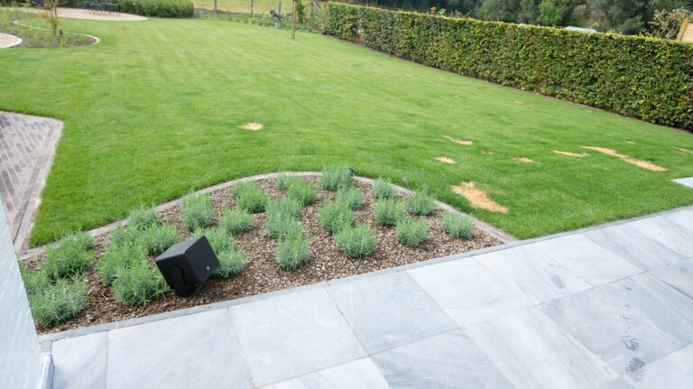 Tuinoverzicht met AUDAC VIRO5-luidspreker in het lavendelperk bij een privéwoning te Voorde